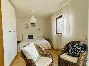 a bedroom with a bed and a chair and a window at Ferienwohnung im Gärtle in Sulzburg