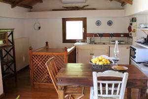 a kitchen with a wooden table with a bowl of fruit on it at Olive Yard House in Skopelos Town