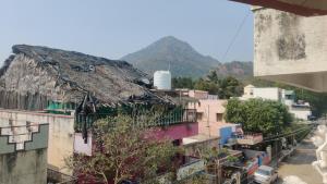 a group of buildings with a mountain in the background at Daya Dharmam Residency in Tiruvannāmalai
