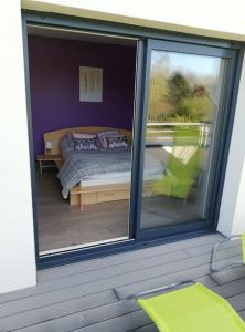 a bedroom with a view of a bed through a window at Maison au calme à 1.5km de la plage classée 4 étoiles in Montmartin-sur-Mer
