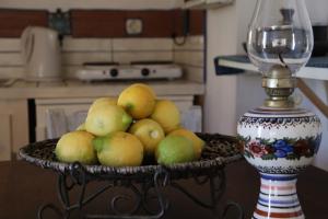 a basket of fruit on a table next to a vase at Olive Yard House in Skopelos Town