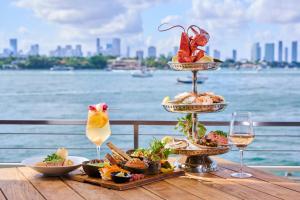 a table topped with plates of food on top of a pier at Mondrian South Beach in Miami Beach