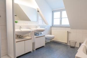 a bathroom with two sinks and a toilet at La Fleur Appartement in Überlingen