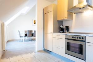 a kitchen with white cabinets and a stove at La Fleur Appartement in Überlingen