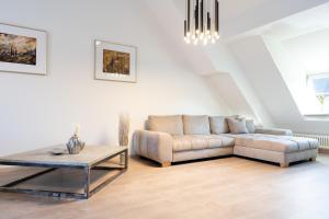 a living room with a couch and a table at La Fleur Appartement in Überlingen