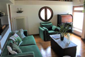 a living room with a green couch and a tv at Olive Yard House in Skopelos Town +13 photos