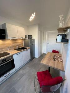 una cocina con mesa y sillas rojas. en komfortable Ferienwohnung in Halle-Kröllwitz en Kröllwitz