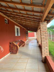 eine überdachte Terrasse mit 2 Sofas und einer Ziegelwand in der Unterkunft Rancho Itokazu in Delfinópolis