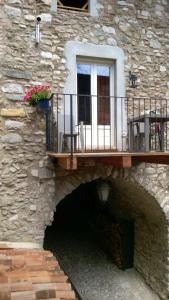 kamienny budynek z balkonem i oknem w obiekcie Casa nel Borgo - Il Picchio w Tremosine Sul Garda