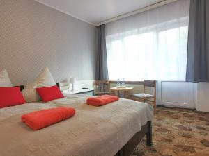 Un dormitorio con una cama con almohadas rojas. en Malinowy Domek en Karpacz