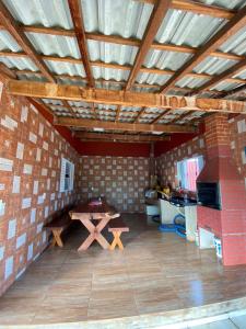 ein Wohnzimmer mit einem Tisch und einer Ziegelwand in der Unterkunft Rancho Itokazu in Delfinópolis