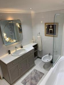 a bathroom with a sink and a toilet and a mirror at Traditional Maltese House in centre of Town in Mosta +23 photos