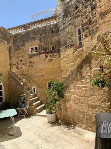 a stone building with stairs and a window and plants at Unique House of Character in centre of Mosta in Mosta