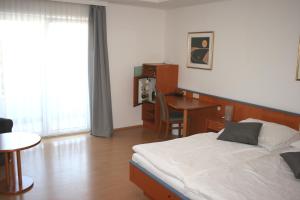 A bed or beds in a room at Sporthotel Podersdorf