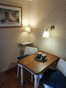 a dining room table with two cups and a lamp at La maison de Céline in Arry
