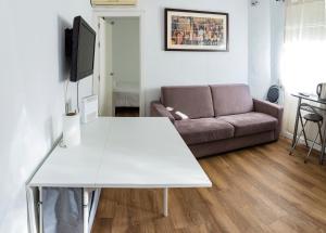 un soggiorno con tavolo bianco e divano di Apartment Triana 2 a Siviglia