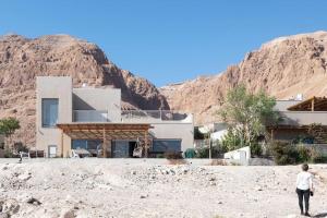 a woman standing in front of a house in the desert at Beautiful home on the dead sea! in Ovnat