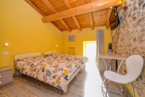 um quarto com uma cama e uma televisão na parede em Casa nel Borgo - Il Gufo em Tremosine Sul Garda