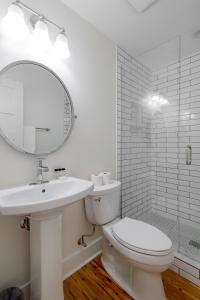 een badkamer met een toilet, een wastafel en een spiegel bij The Quarters on Spring in Charleston