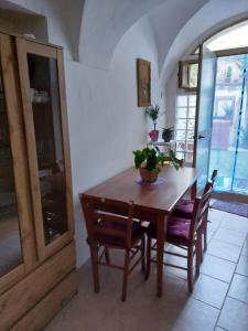 薩薩里的住宿－Appartamentino con cortile, Sassari Centro Storico，一间带木桌和椅子的用餐室