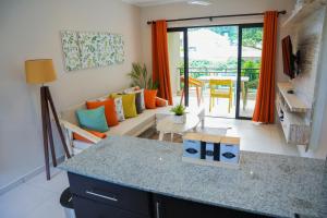 cocina y sala de estar con sofá y mesa en Hidden Valley Residence en Au Cap