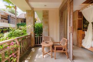 a patio with two chairs and a table on a balcony at The Udaya Resorts and Spa in Ubud