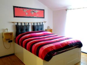 a bedroom with a bed with a striped blanket at Crêuza da me ღ in Genova