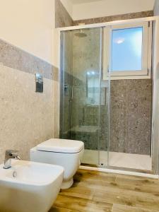 ein Bad mit einer Dusche, einem WC und einem Waschbecken in der Unterkunft Nuova Residenza dei 7 Pini a pochi passi dal mare in Porto Pino