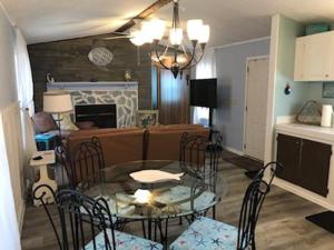 a living room with a glass table and chairs at Holden Beach Your Way in Holden Beach