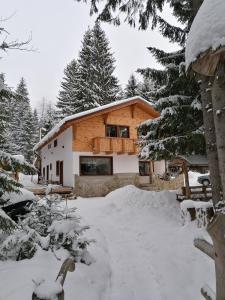 ein Haus mit Balkon im Schnee in der Unterkunft Four Season Komando in Comandău