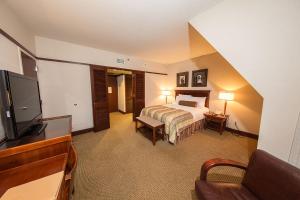 a hotel room with a bed and a flat screen tv at Alyeska Resort in Girdwood