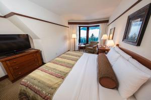 a hotel room with a large bed and a television at Alyeska Resort in Girdwood