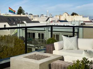 een balkon met een bank en uitzicht op de stad bij The Hotel Castro San Francisco in San Francisco