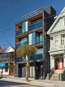 um edifício numa rua da cidade com uma árvore em frente em The Hotel Castro San Francisco em São Francisco