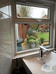 
a white sink sitting under a window in a bathroom at 1560 by the Racecourse in Cheltenham
