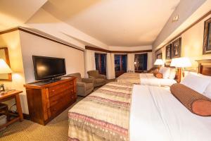 a hotel room with two beds and a flat screen tv at Alyeska Resort in Girdwood