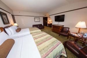 a hotel room with a bed and a flat screen tv at Alyeska Resort in Girdwood