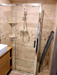 a shower with a glass door in a bathroom at Apartament Rewal in Rewal