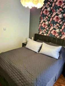 a bedroom with a bed with a flower mural on the wall at Apartament Rewal in Rewal