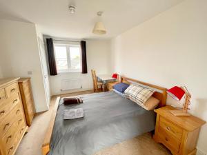 a bedroom with a large bed and a desk at Basingstoke Townhouse Near Hospital in Basingstoke