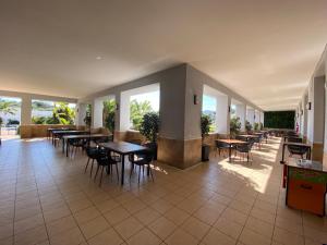 un restaurante con mesas, sillas y ventanas en Hotel Montera Plaza, en Los Barrios