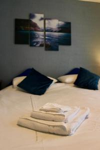 a bed with a pile of towels on it at Bryn Noddfa in Morfa Nefyn