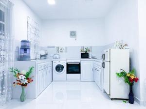 a white kitchen with a refrigerator and a dishwasher at Mount edge riverside hotel in Bandarawela in Bandarawela