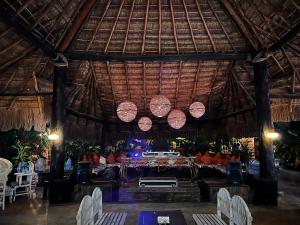 a restaurant with a table with chairs and lights at Luhme Tulum Hostel in Tulum