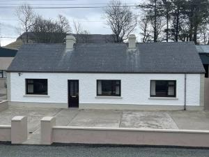 una casa blanca con techo negro en Grogagh Hill Cottage en Sligo