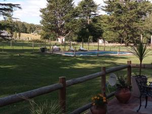 valla de madera con piscina en un parque en Cabañas Cuncumen en Tandil