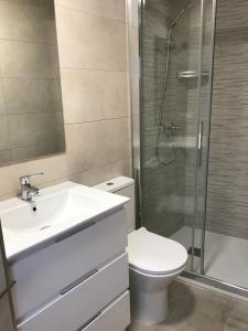 een badkamer met een toilet, een wastafel en een douche bij Casa Valentin in Baíñas