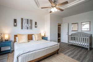 a bedroom with a bed with a ceiling fan and a crib at Luxury Estate in Prime Location w Panoramic views of Lake Havasu in Lake Havasu City +60 photos