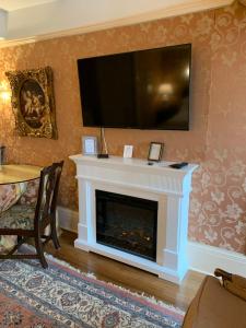 sala de estar con chimenea y TV de pantalla plana en Gramercy Mansion, en Stevenson