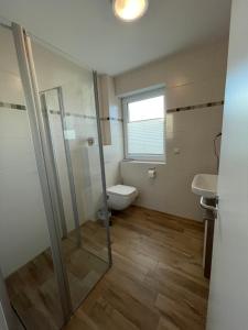 a bathroom with a shower and a toilet and a sink at Wangerkajüte in Wangerland